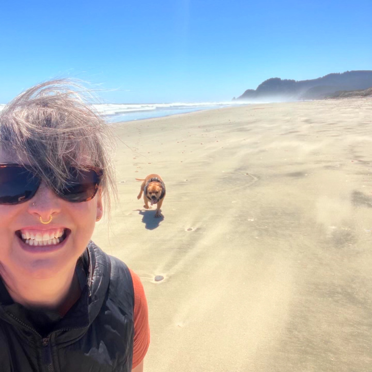 A woman enjoying on the beach with her dog